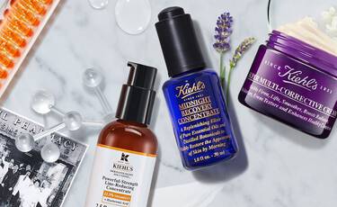 Kiehl’s skincare products including Powerful-Strength Line-Reducing Concentrate, Midnight Recovery Concentrate and Super Multi-Corrective Cream on marble background